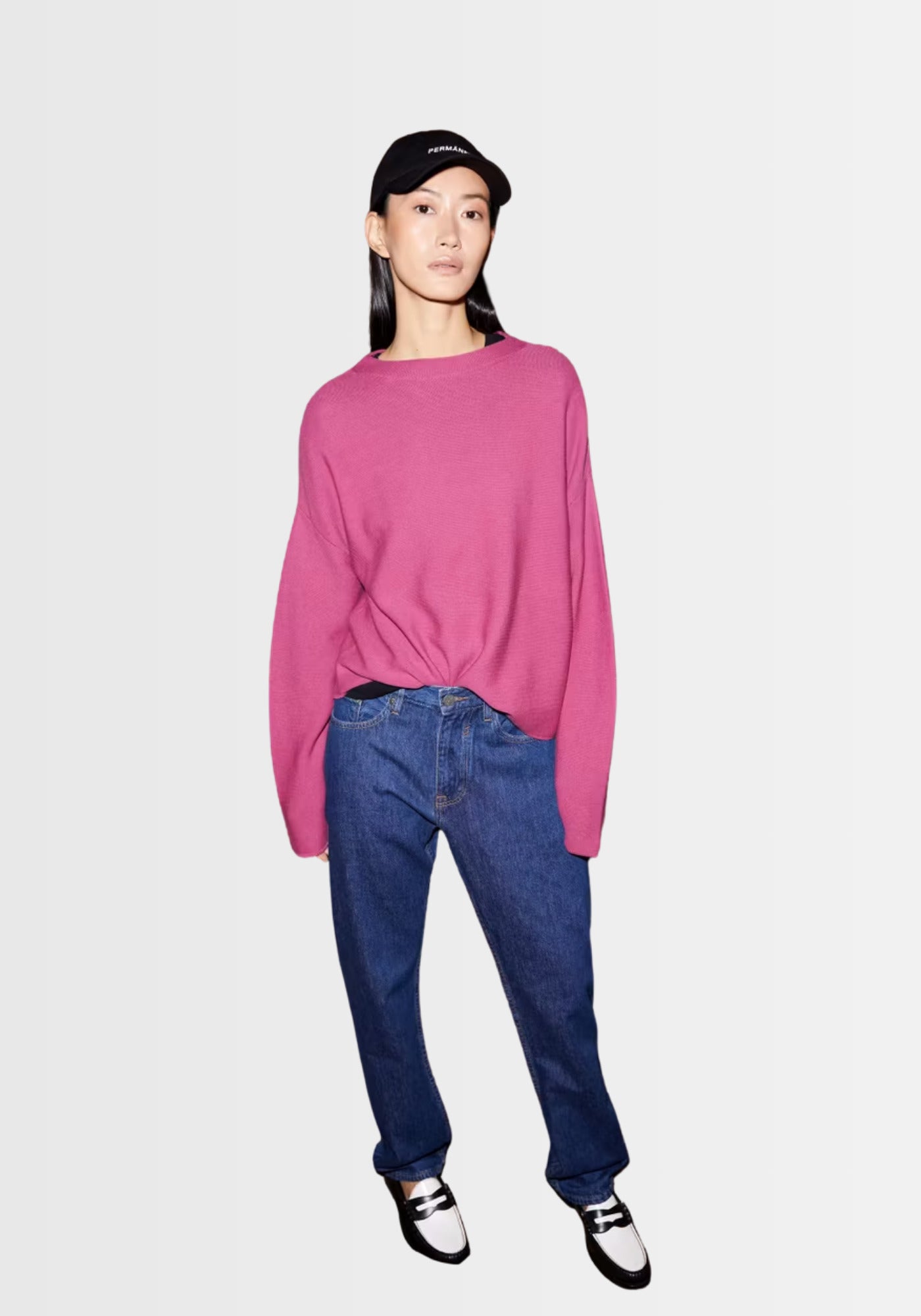 Frau präsentiert den pinken Merinaa Sweater aus 100% Bio-Baumwolle mit Mock Neck, zusammen mit einer Jeans und Sneakern für einen urbanen Alltagslook.