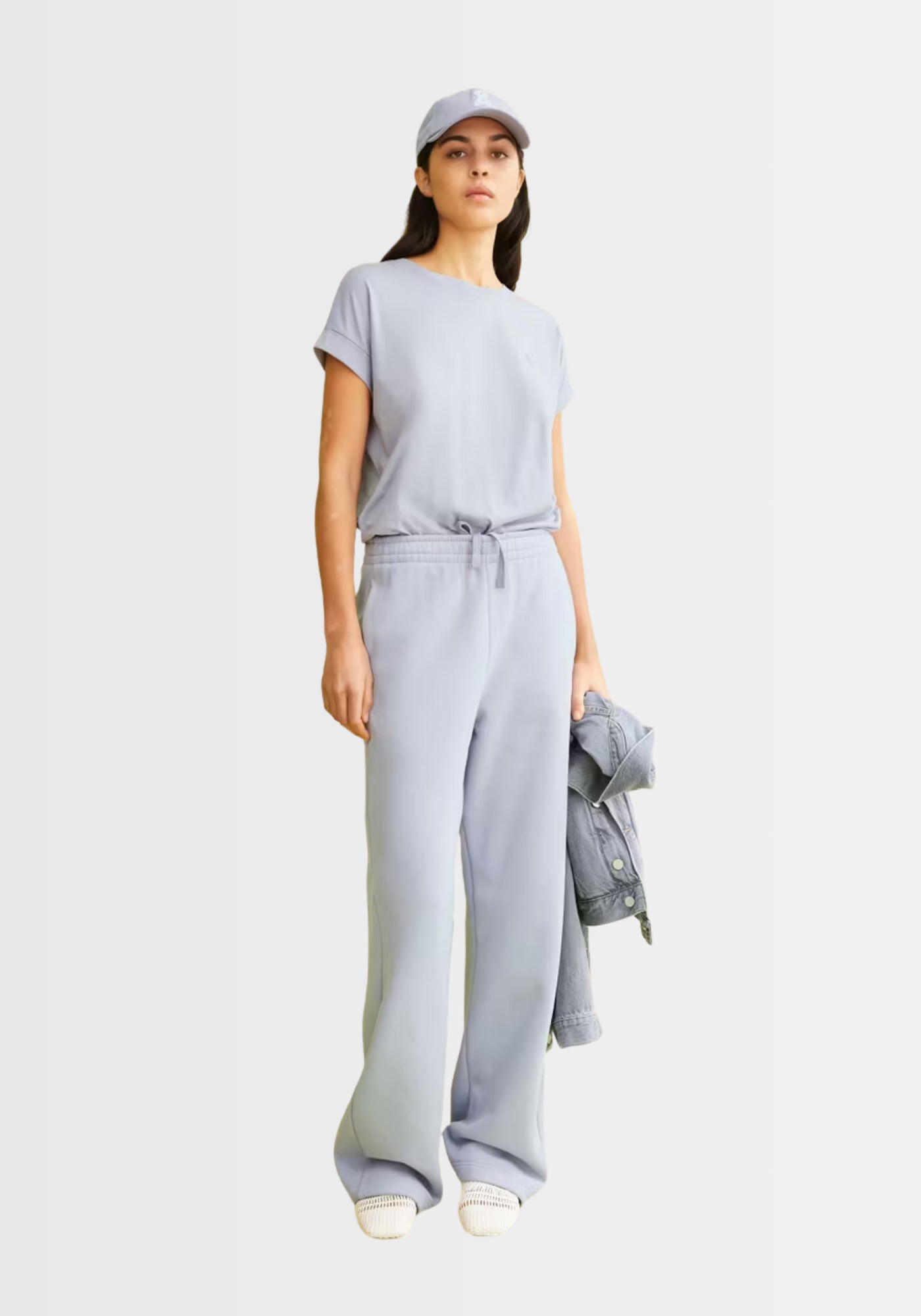 Frau präsentiert das locker geschnittene Idaara T-Shirt in Misty Morning, kombiniert mit einer weiten Hose und Sneakern, für einen lässigen Alltagsstyle.