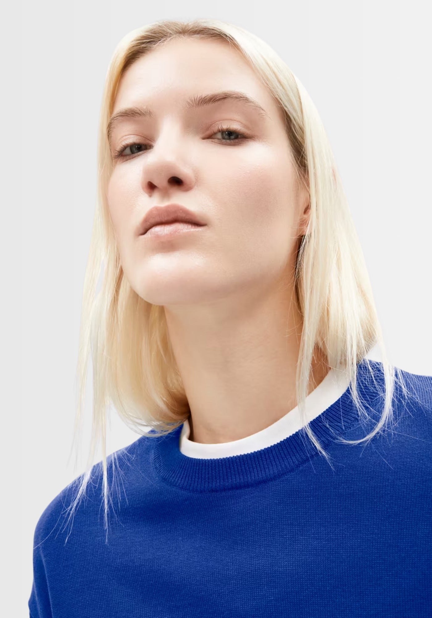 Nahaufnahme des extra feinen Strickmusters des Sweaters in lapis blue, aus hochwertiger Bio-Baumwolle und TENCEL™ Lyocell, der für eine weiche Haptik sorgt.