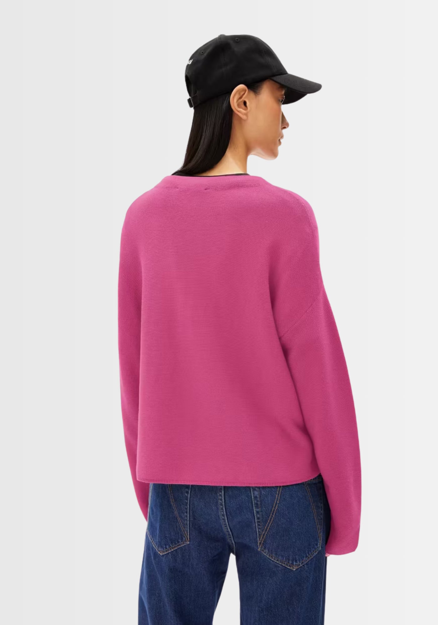 Hinteransicht des Merinaa Links Links Pullovers in kräftigem Pink, zeigt die lockere Passform und das verkürzte Design am Rücken.