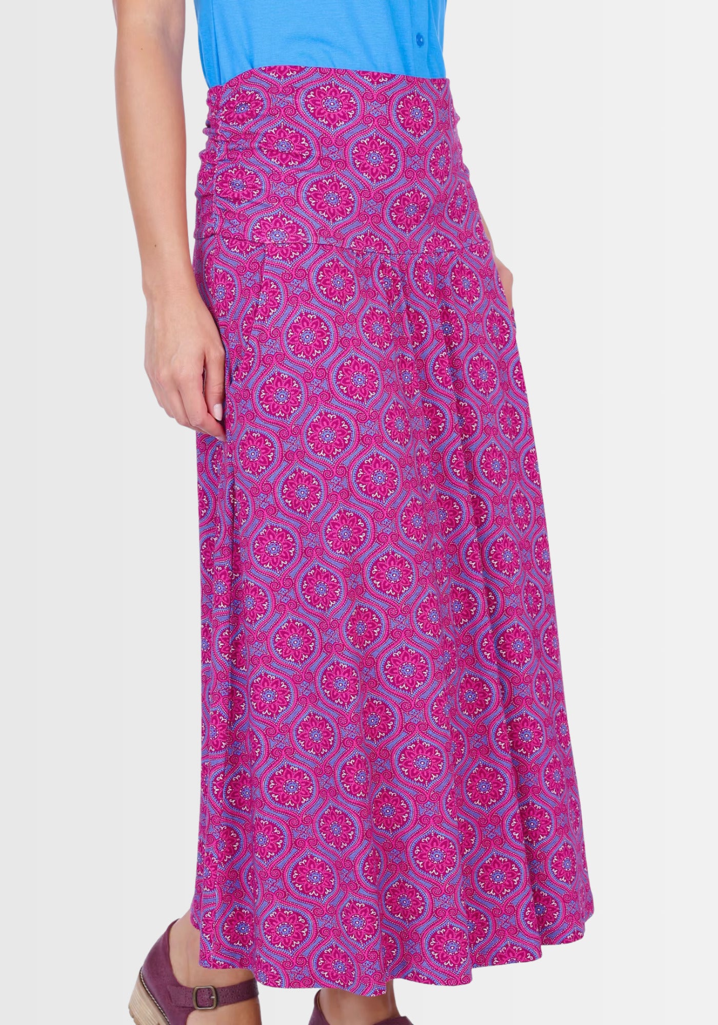 Lifestyle-Aufnahme des Rocks „Kalla“ in leuchtendem Himbeerrot mit Mandala-Print. Kombiniert mit einem schlichten Oberteil und Sandalen entsteht ein leichter, boho-inspirierter Sommerlook, perfekt für Alltag und Freizeit.