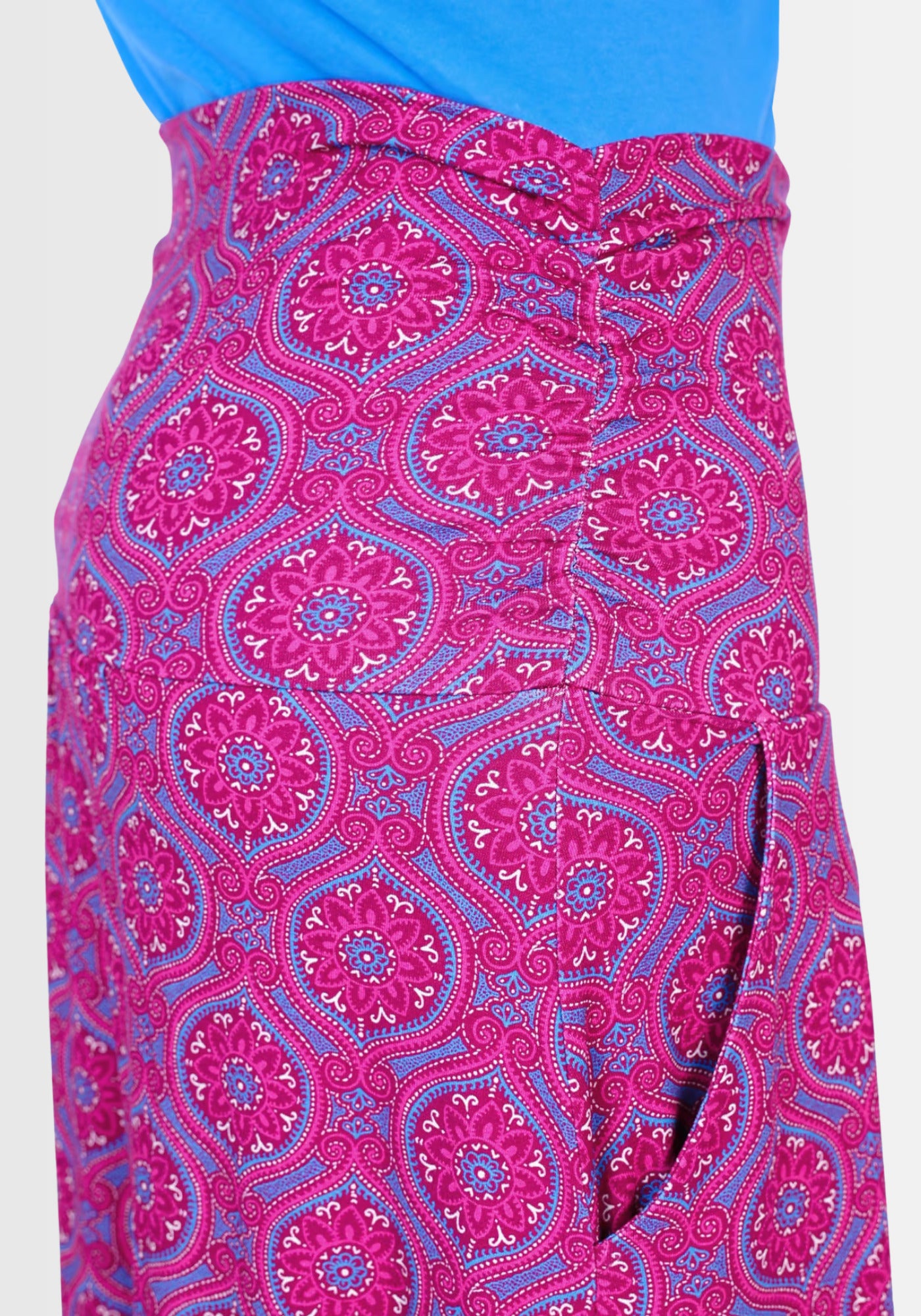 Seitenansicht des Rocks „Kalla“ in auffälligem Mandala-Design. Die praktischen Eingrifftaschen verleihen ihm einen lässigen Touch, während das nachhaltige LENZING™ ECOVERO™-Material angenehm auf der Haut liegt.