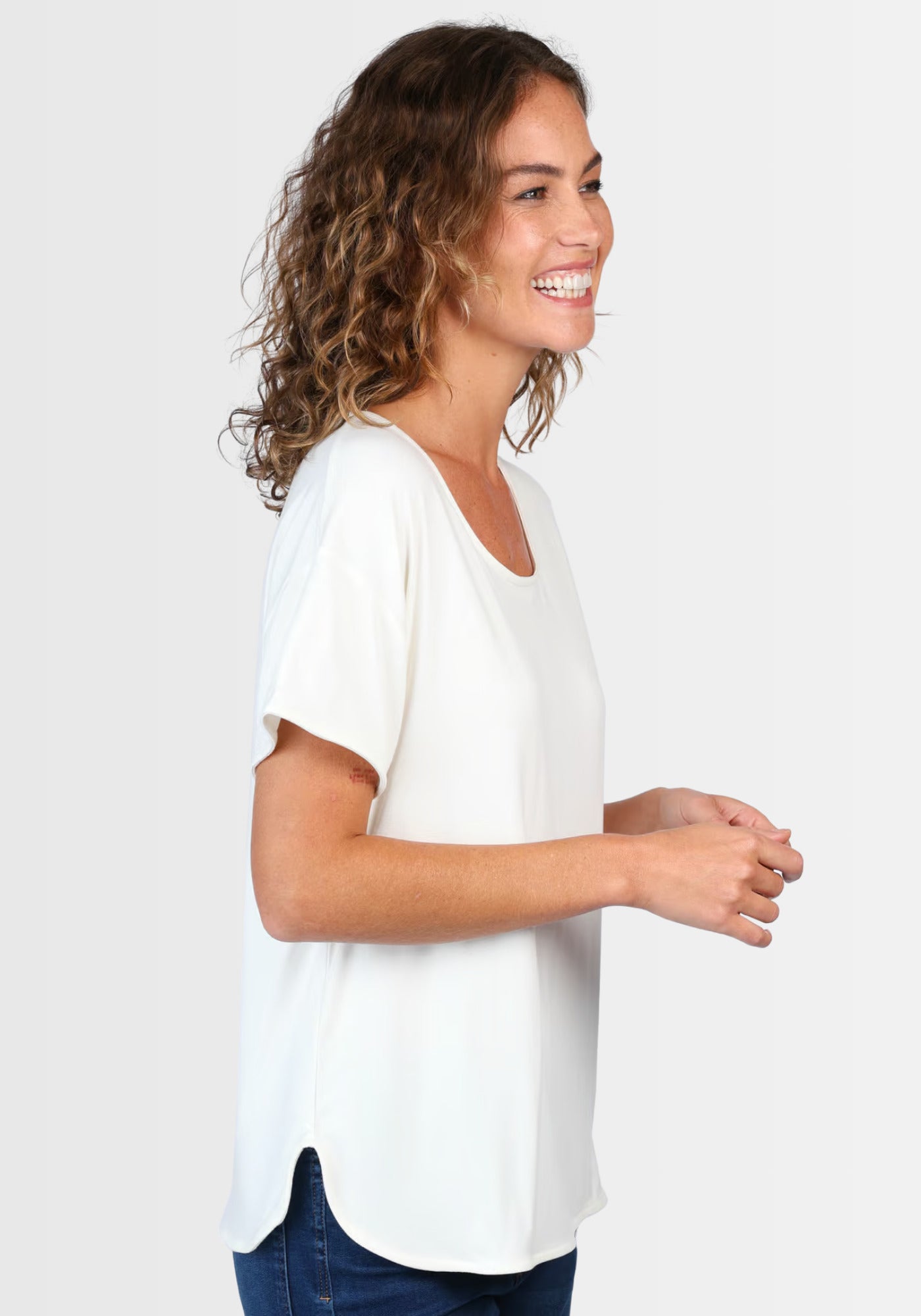 Seitenprofil des locker geschnittenen T-Shirts „Betzi“ in Elfenbeinweiß, hergestellt aus nachhaltiger LENZING™ ECOVERO™-Viskose und Elasthan für maximalen Tragekomfort.