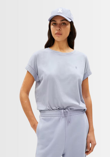 Model trägt das bequeme Idaara T-Shirt mit passender Baseballkappe und passendem Jogger, für einen modernen und sportlichen Freizeitlook in Graublau.