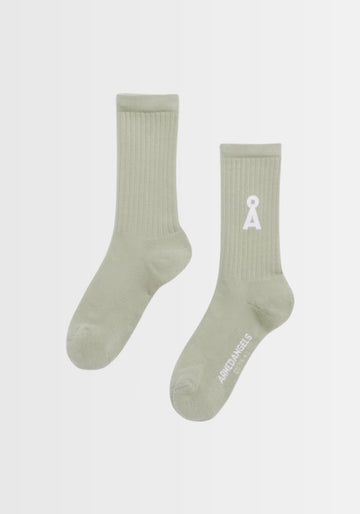 Freigestellte Ansicht der leuchtend grünen SAAMUS BOLD Socken in „seagreen“, mit markantem Logo und elastischem Bündchen. Hergestellt in Braga, Portugal, verbinden sie Komfort und Umweltbewusstsein dank Bio-Baumwolle, recyceltem Polyamid und veganer Zertifizierung.

