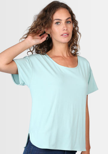 Model präsentiert das T-Shirt "Betzi" in einem frischen Turquoise-Ton, gefertigt aus 95% LENZING™ ECOVERO™ Viskose und 5% Elasthan. Der schlichte Rundhalsausschnitt und der locker geschnittene Stil machen es zum idealen Basic für jeden Tag.