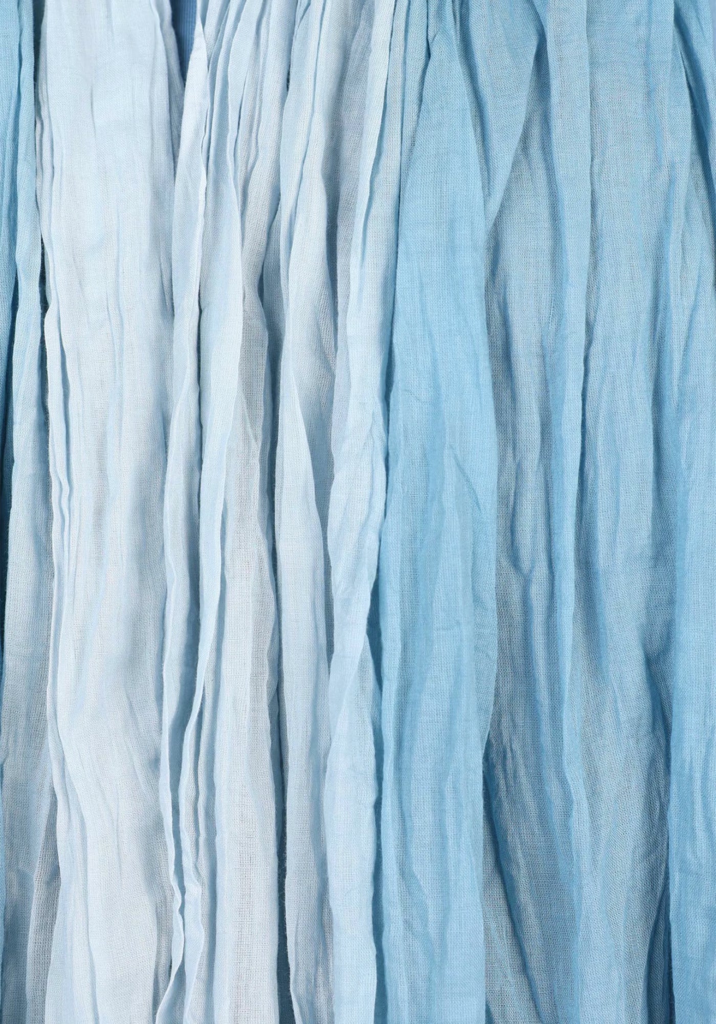 Detailaufnahme der feinen, weichen Baumwollstruktur des Tuchs „Asta – Swedish Blue“. Der dezente Farbverlauf und die hochwertige Verarbeitung machen es zu einem eleganten, alltagstauglichen Accessoire.

